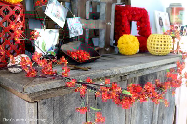 red floral sprays wrapped around wood mantel
