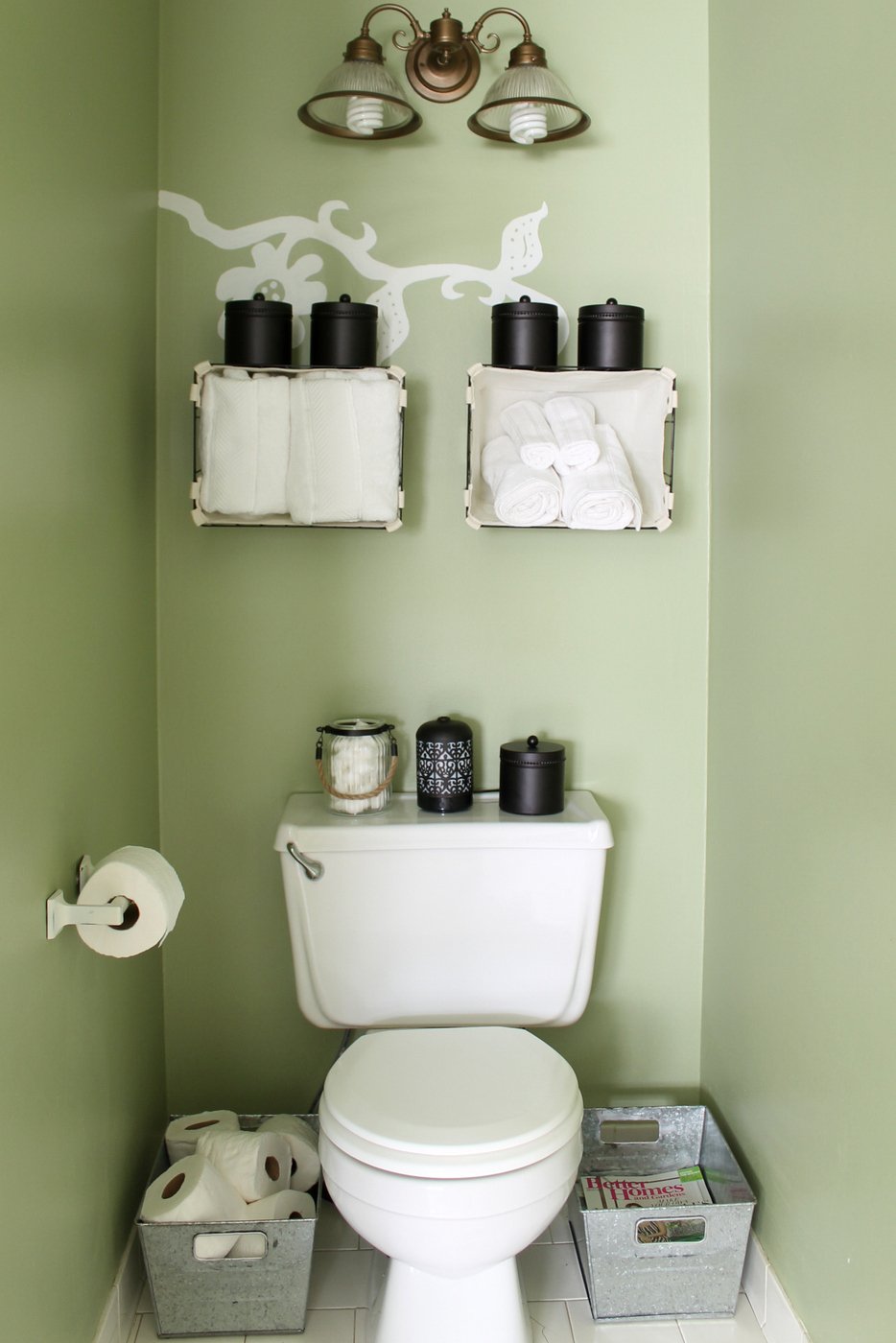 Wire baskets hanging on the wall above the toilet 