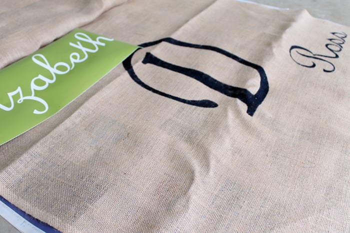 name stencils cut from vinyl being added to a burlap aisle runner