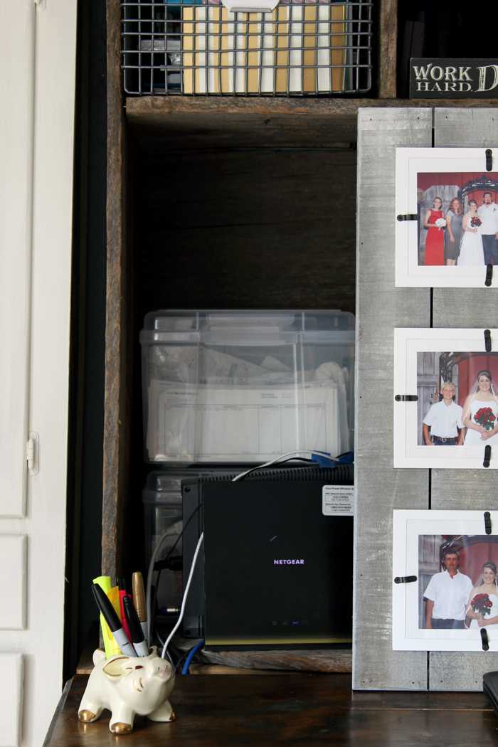 This rustic wood picture frame helps hide the wires and boxes that come with a home office work space!