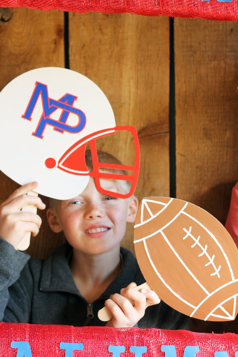 boy holding football and helmet photo booth accessories