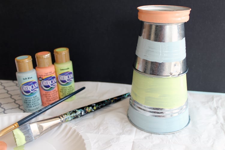 Painting pails and mason jar lids for garden DIY lighthouse