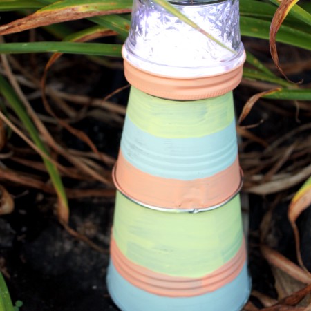 Make this garden lighthouse for your outdoor decor! A fun DIY project that is perfect for your yard!