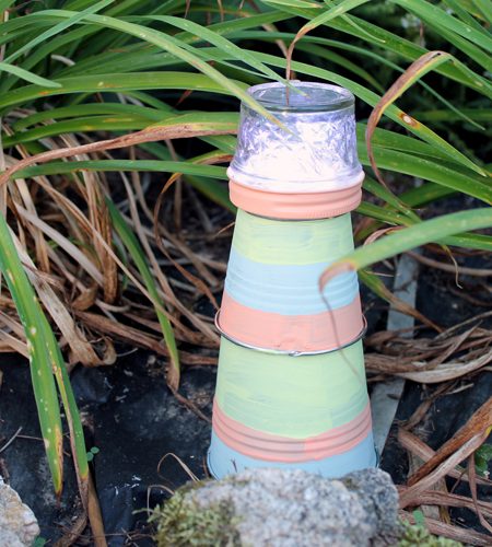 Make this garden lighthouse for your outdoor decor! A fun DIY project that is perfect for your yard!