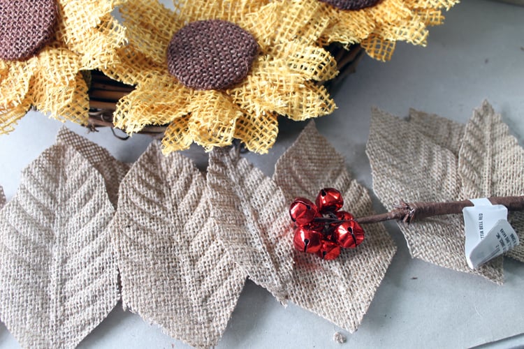 burlap poinsettia petals spread out on a table next to the wreath