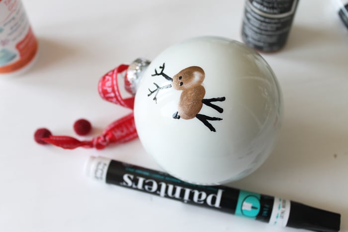 reindeer fingerprint ornament next to a paint pen