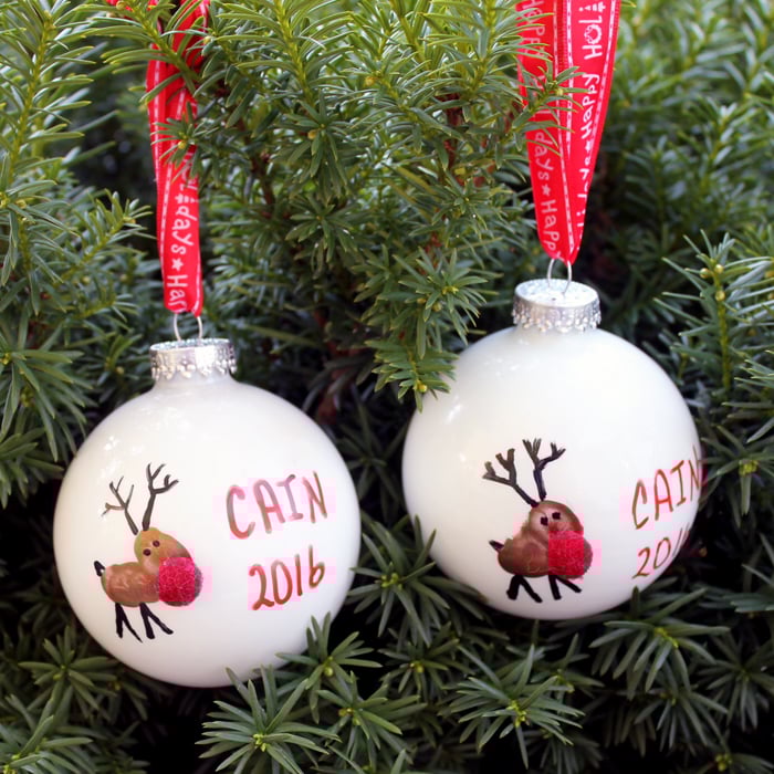 2 reindeer christmas ornaments hanging on a tree.