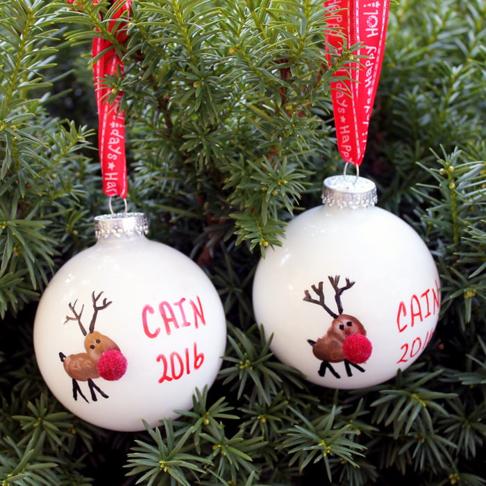 2 reindeer christmas ornaments hanging on a tree. 