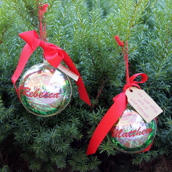 2 ornaments filled with money hanging on a christmas tree 