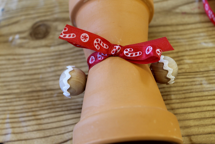 bow and arms added to terra cotta pot gingerbread man