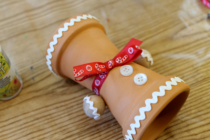 glue buttons to gingerbread man terra cotta pot