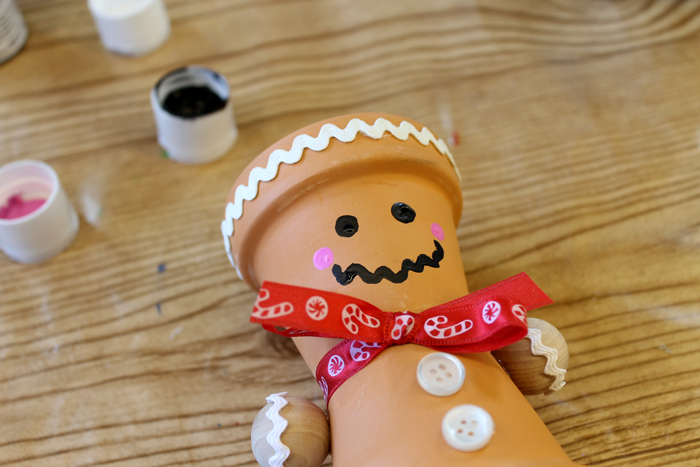 paint gingerbread man's face onto terra cotta pot