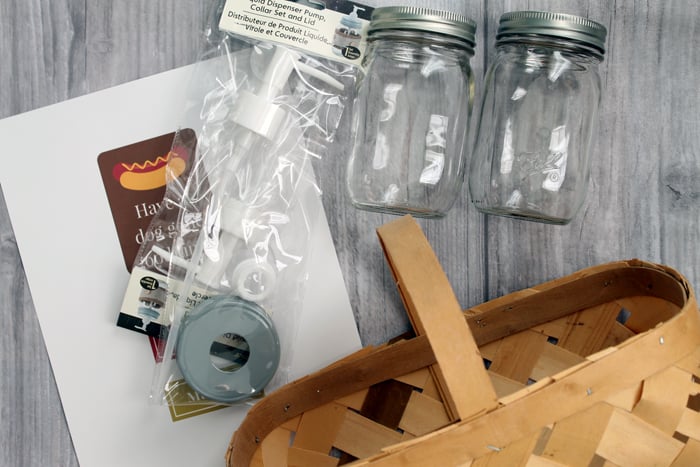 Supplies for a hot dog gift basket - a basket, mason jars, and pumps