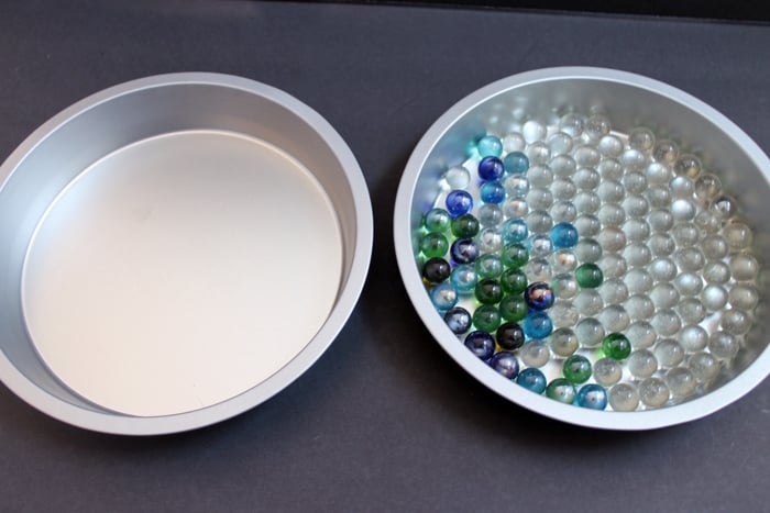 two cake pans with marbles inside