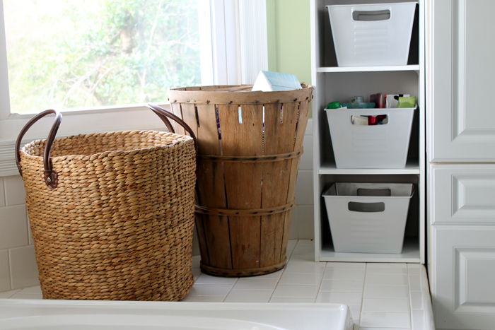 white bins and brown hampers in bathroom