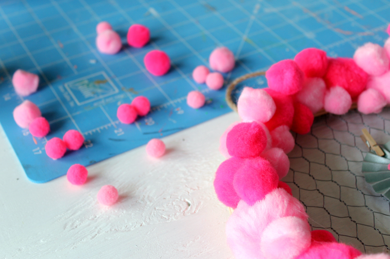 top shot of pink pompoms scattered on craft table
