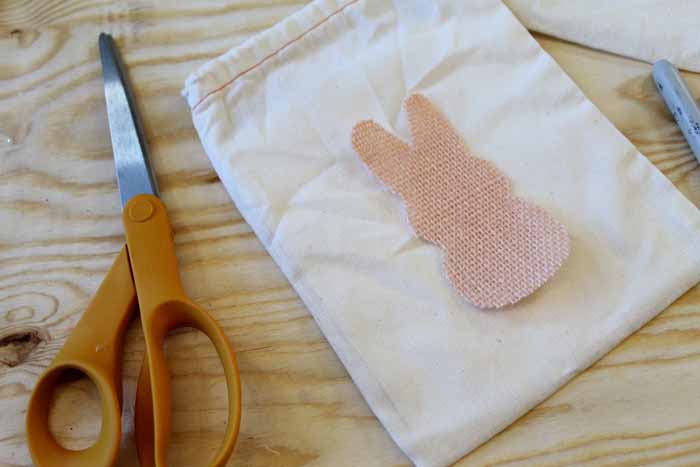 adhering burlap bunny shapes on bag