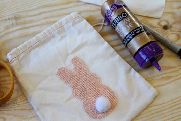 gluing a bunny tail on a easter treat bag