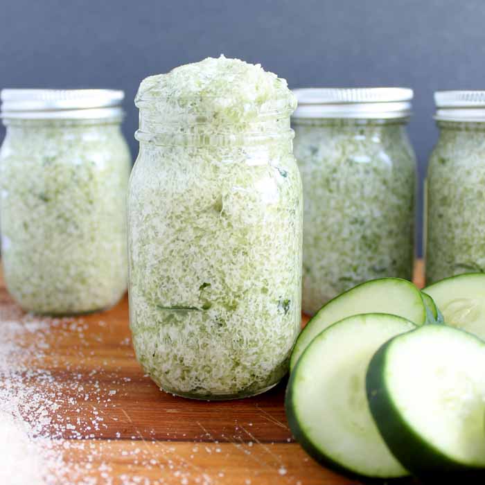 four jars of sugar scrub with sliced cucumbers