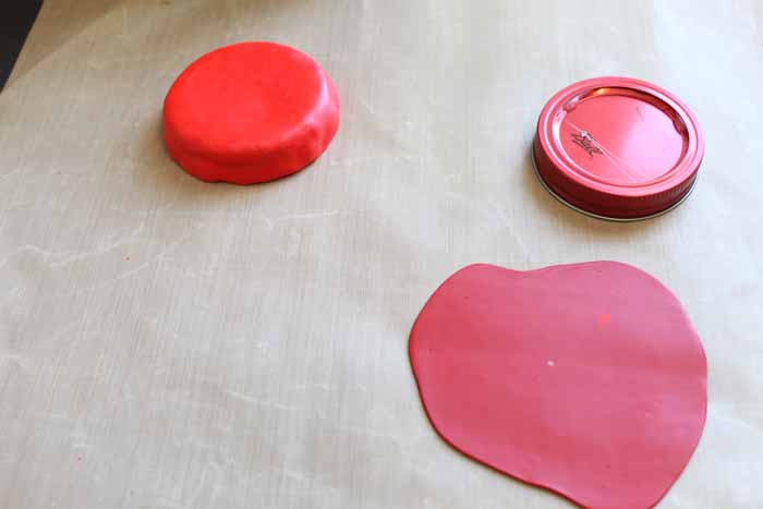 adding red clay to the top of a mason jar lid