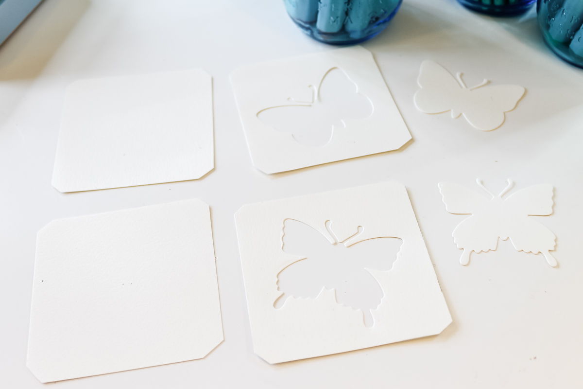 white paper squares with butterfly cut outs
