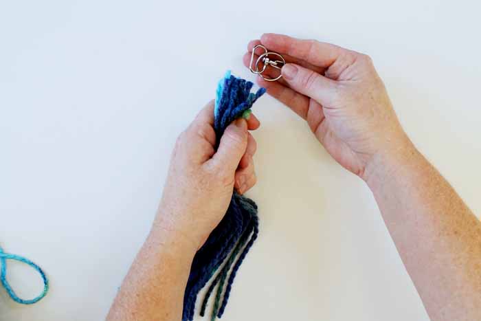 pulling yarn strands through the hook portion of the keyring