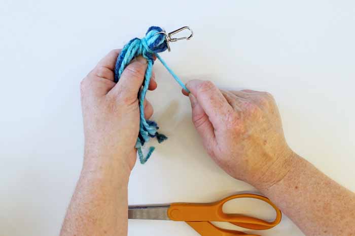 Tying the yarn around the tassel as shown below