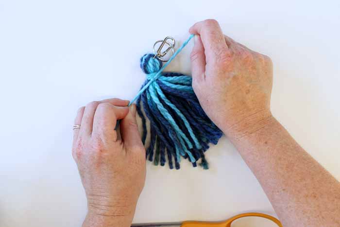 after wrapping the yarn around the tassel several times, tie it securely