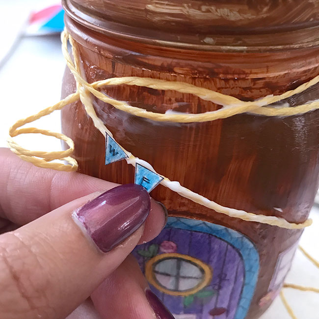 Use mod podge to add more details to your mason jar fairy home
