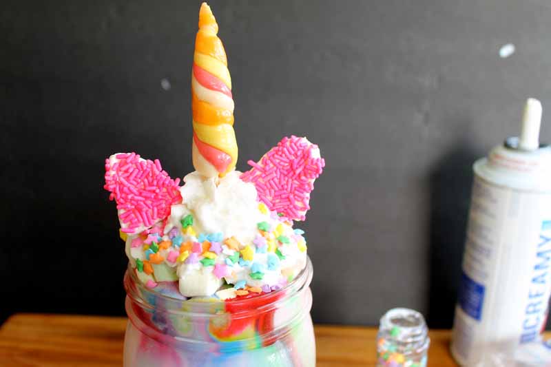 Colorful milkshake in mason jar with unicorn ears and horns