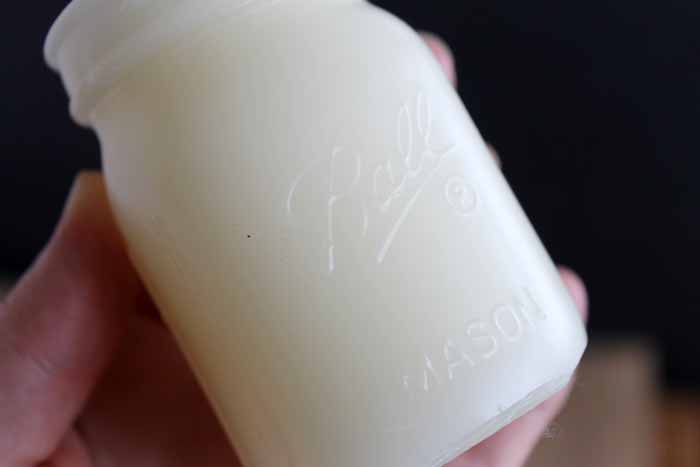 up close image of white mason jar shaped candle