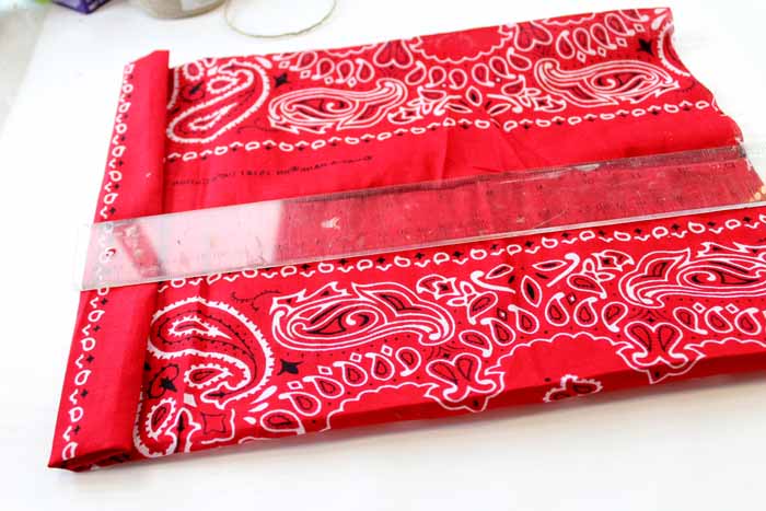 measuring red bandanna with ruler