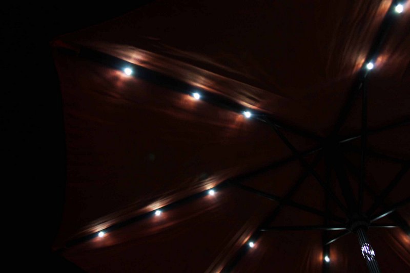 solar lights on a patio umbrella at night