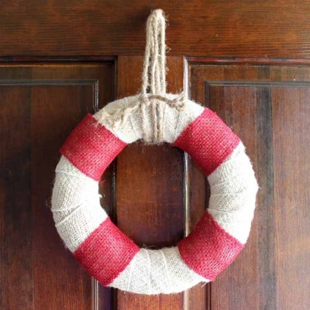 Make this DIY burlap wreath that looks like a life preserver! Perfect for summer and beach themed decor!