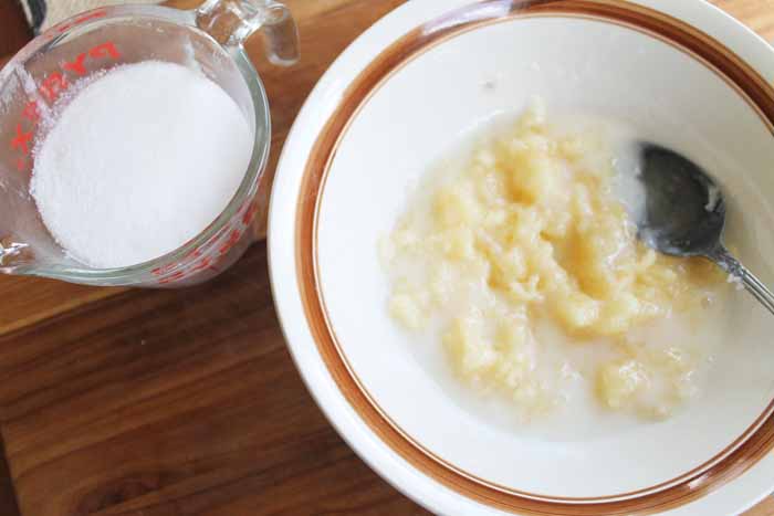 A bowl of pineapple on a wood table