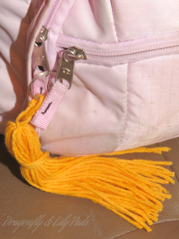 tassel added to a light pink bag