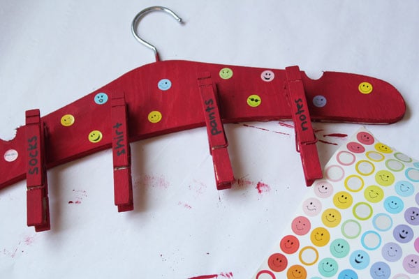 red painted hanger with clips and polka dots on white background