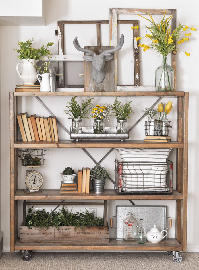 farmhouse decorated shelving unit with books, flowers and antique home accessories