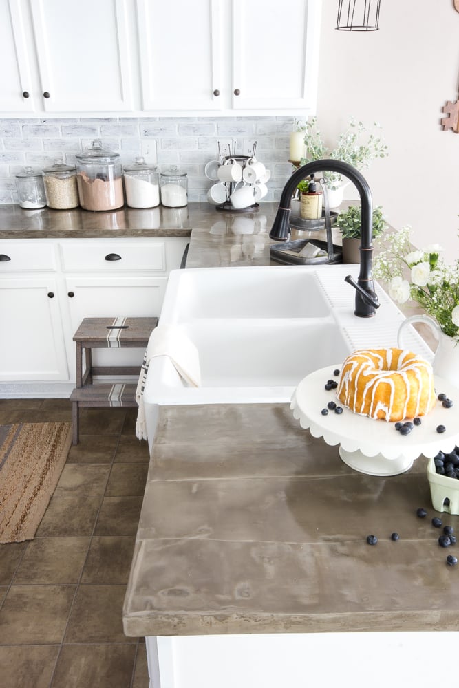 kitchen with concrete countertops with white cake plate and bundt cake