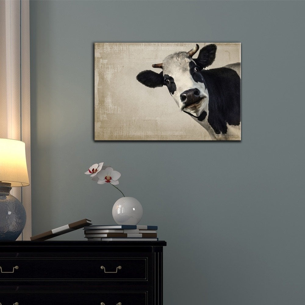 cow painting on blue wall with black side table with lamp and orchid