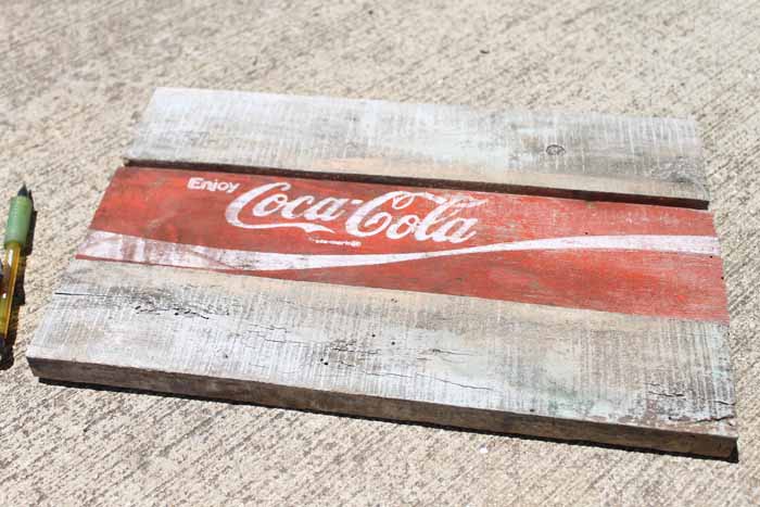 two wooden pieces with a coca cola sign on concrete