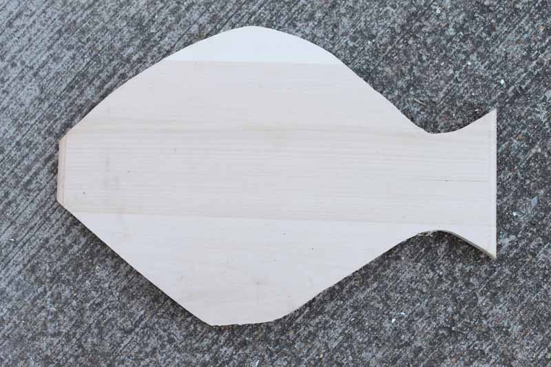 fish shaped unfinished wood on gray carpet