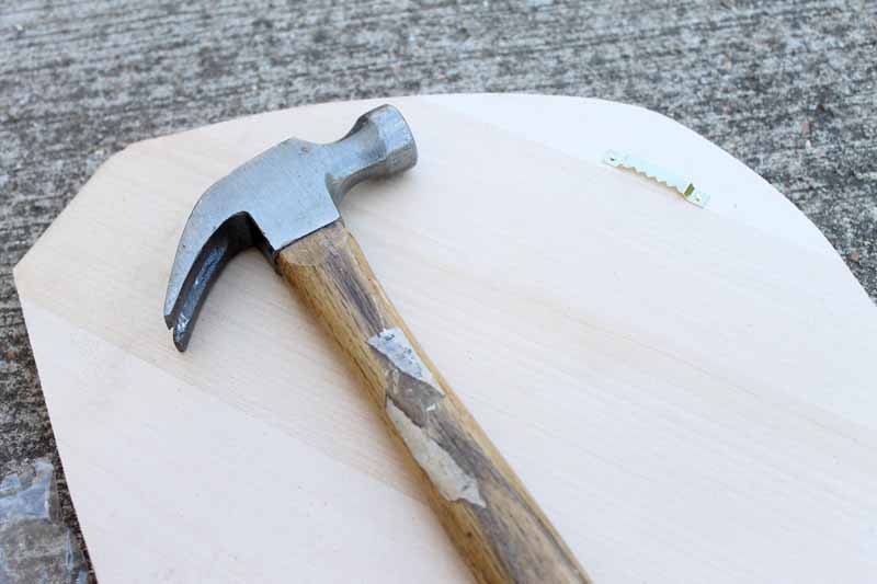 hammer on top of unfinished wood plaque