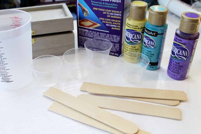 image of three clear plastic cups, tongue depressors and craft paint