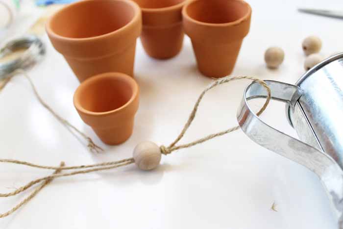 adding twine to hand of watering can