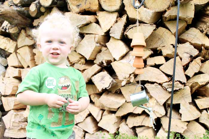 toddler stand next to homemade wind chimes