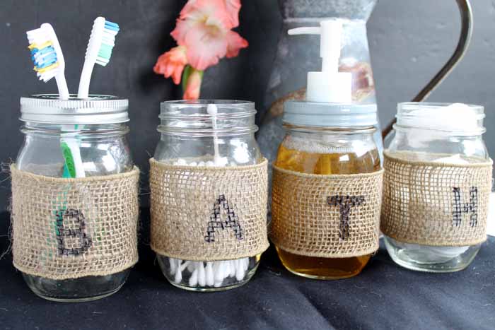 4 mason jars with burlap ribbon and the word bath written on them