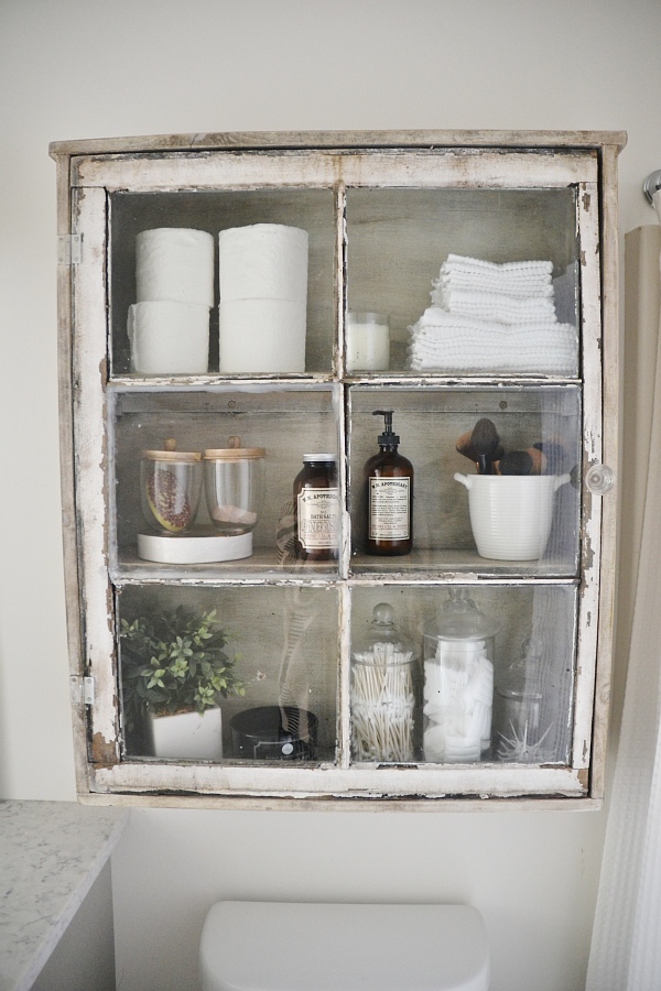 This old rustic window is perfect bathroom storage and I love how vintage it looks!