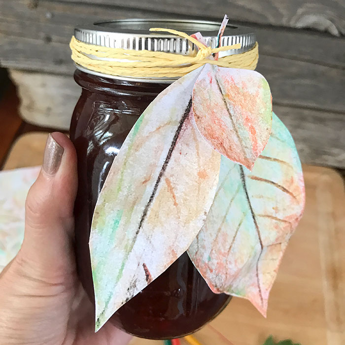 Close up of mason jar with watercolor leaves gift tags