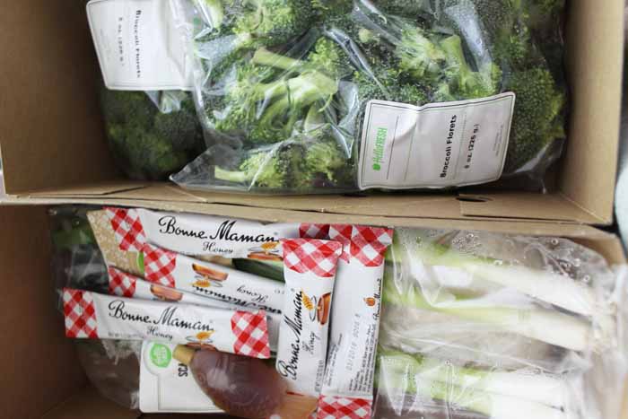 A plastic bag full of broccoli, with Hello Fresh and Blue Apron